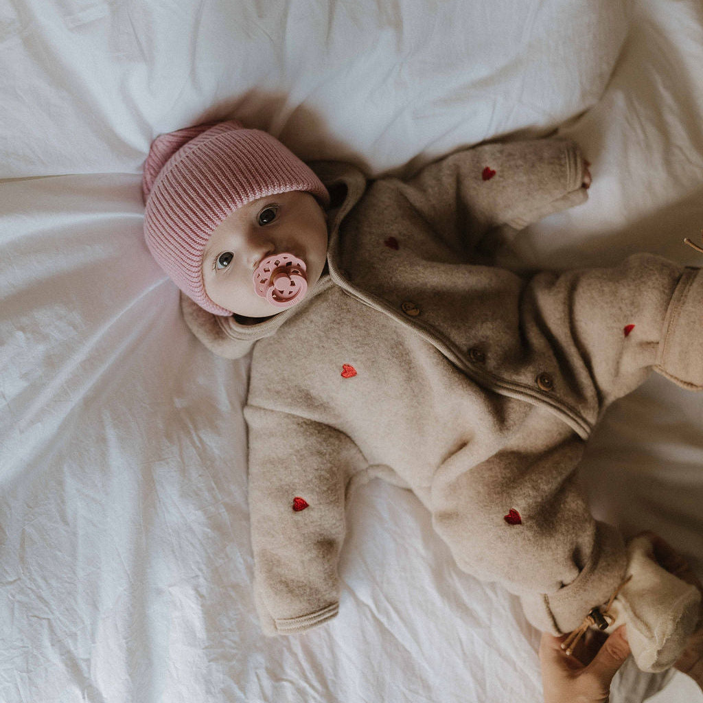 Engel natur overall wolfleece sand limited edition aan bij baby op bed